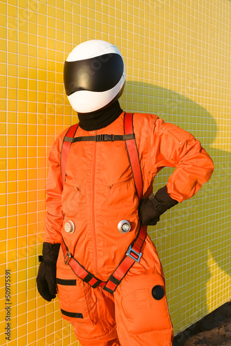 Confident cosmonaut against yellow wall