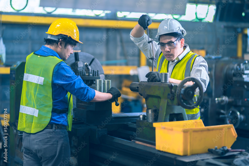 The worker teammate engineer white and yellow safety helmet during fix and working together in the product line The worker teammate engineer white and yellow safety helmet during fix and working together in the product line