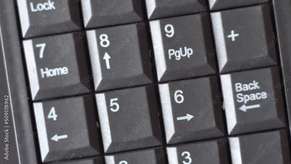 Black keyboard with numbers. White arrows and numbers. Mini Keyboard. Electronic device. Calculator. Computer device. Device rotation. Close-up. Macro photography.