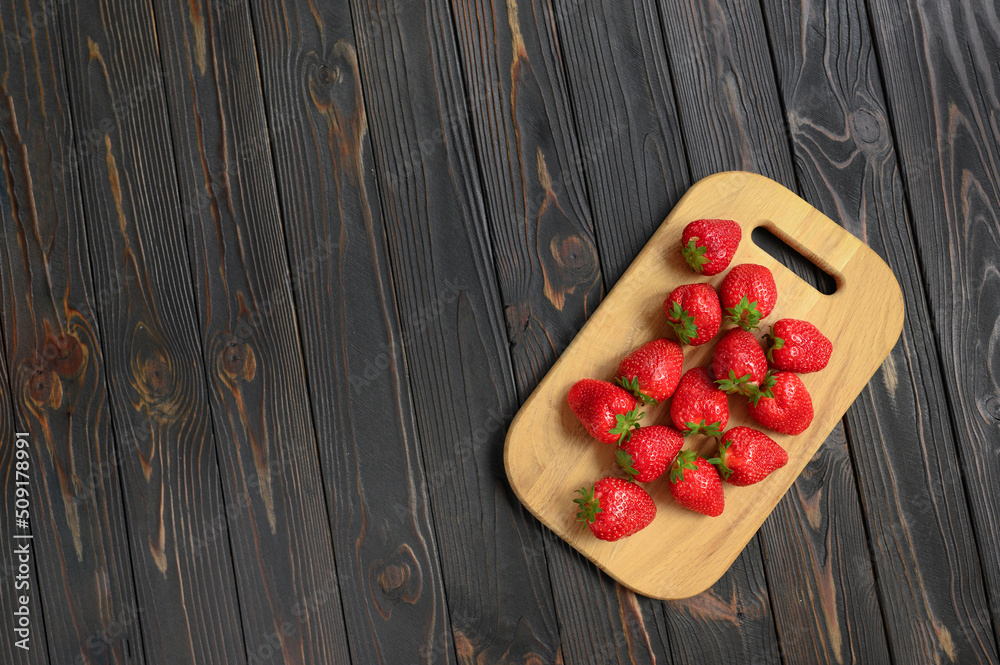 Red juicy strawberries on a rustic wooden table. The concept of healthy and dietary snacks. Red juicy strawberries on a rustic wooden table. The concept of healthy and dietary snacks.