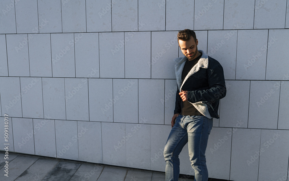 Man leaning on wall under sunlight Man leaning on wall under sunlight