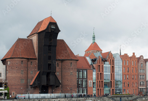 Motlawa River Embankment in Gdansk. View of the river with ships, the old town and the crane gate Zhurav. Historical and tourist attractions in Poland