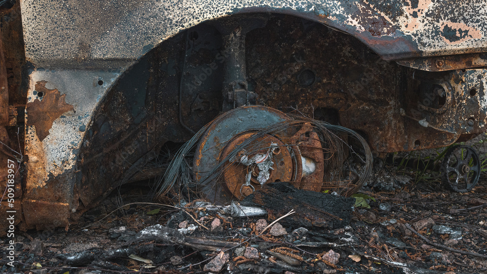 The war in Ukraine, a burned civilian car, a burned wheel and a running gear