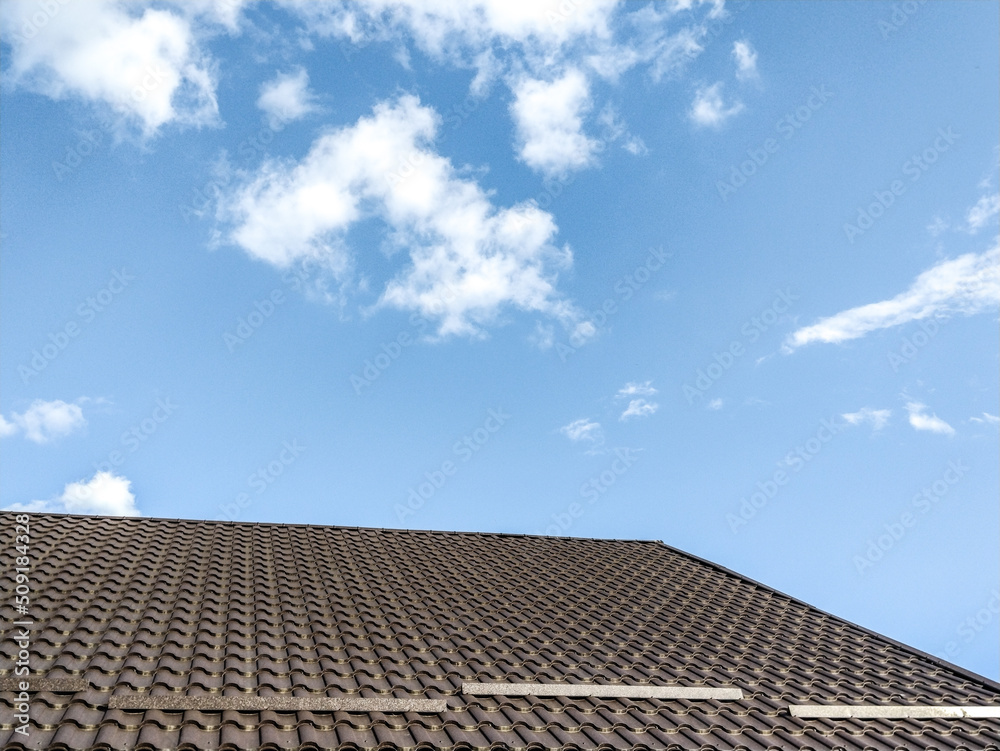 the tiled roof of a house and a clear sky