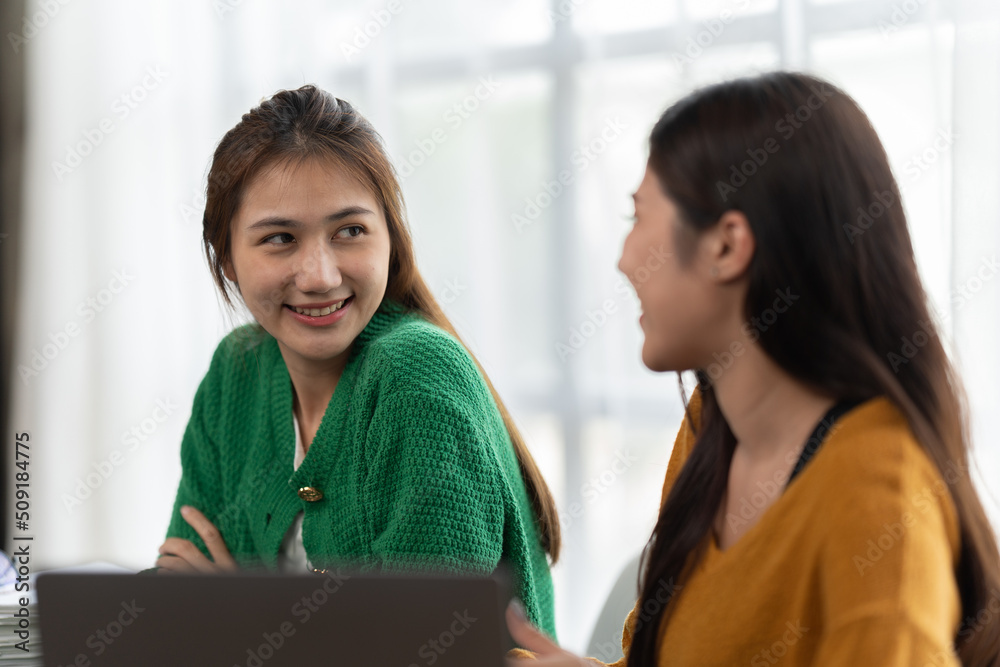 Two asian women discussing business projects in a office while having coffee. Startup, ideas and brain storm concept. Two asian women discussing business projects in a office while having coffee. Startup, ideas and brain storm concept.