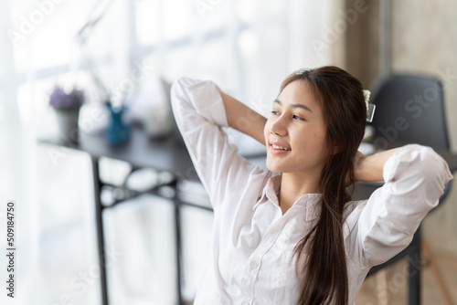 Portrait of beautiful asian woman relaxing in office, Happy relaxed woman having break and resting in office. photo