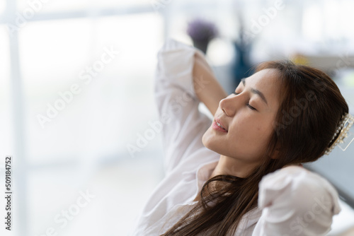 Portrait of beautiful asian woman relaxing in office, Happy relaxed woman having break and resting in office. © PaeGAG