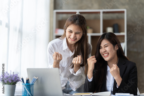 Coworkers looking at a computer and discussing over new business plan. Business team working together on computer in office,