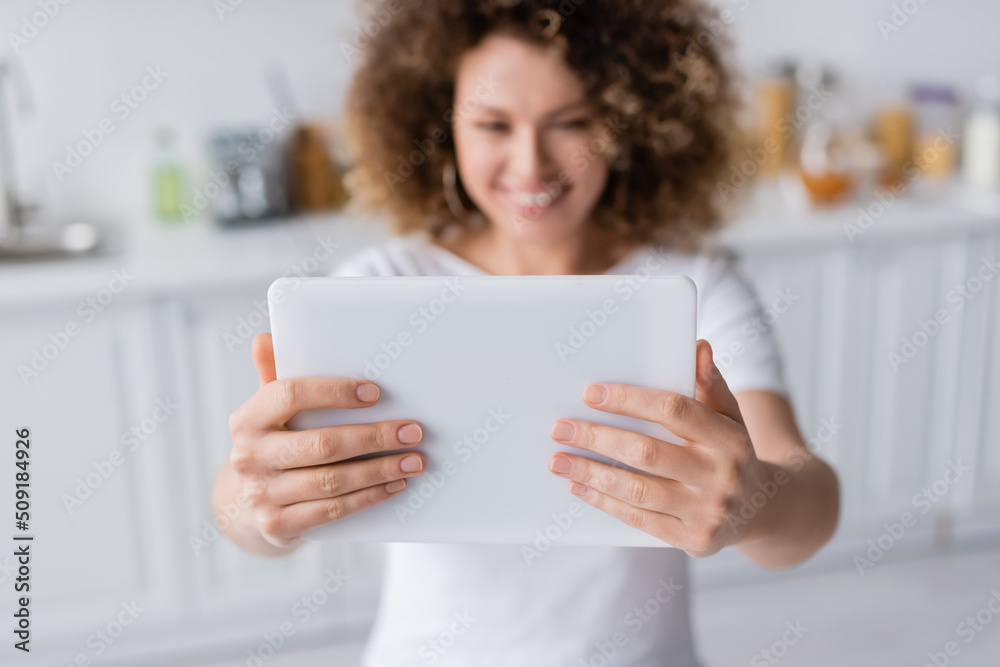 selective focus of digital tablet in hands of smiling woman taking selfie on blurred background. selective focus of digital tablet in hands of smiling woman taking selfie on blurred background.