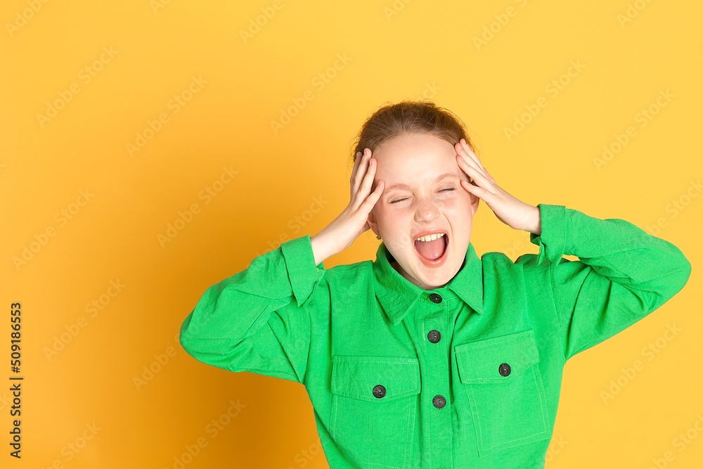 Emotional Portrait of a laughing cute little girl in the studio on a yellow background, emotions, sign language. the child smiles and looks at the camera and shows emotions Emotional Portrait of a laughing cute little girl in the studio on a yellow background, emotions, sign language. the child smiles and looks at the camera and shows emotions