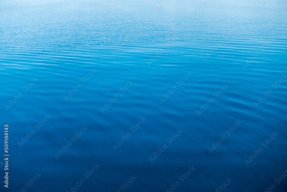 Clear water texture in blue and orange. Background of the ocean and the sea backlit by the sun. Natural water Clear water texture in blue and orange. Background of the ocean and the sea backlit by the sun. Natural water