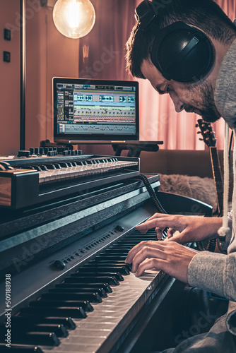 Photography A male musician plays the musical keys in headphones.