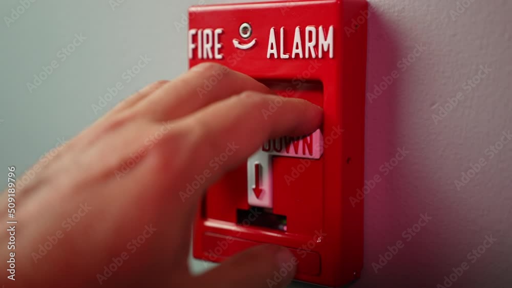 An extreme slow motion closeup view pulling down a fire alarm in a commercial building.  	