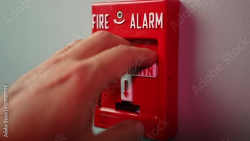 An extreme slow motion closeup view pulling down a fire alarm in a commercial building.  	