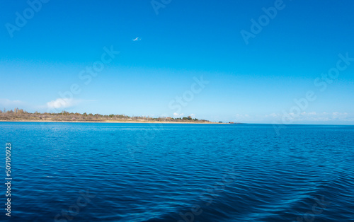 Sverny shore of Lake Issyk-Kul  Kyrgyzstan. View from the ship to the shore. Blue water of a mountain lake.
