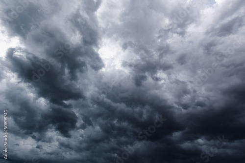 The dark sky with heavy clouds converging and a violent storm before the rain.Bad or moody weather sky..