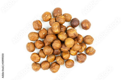 Peeled hazelnuts on a white isolated background. A handful of nuts (a lot) close-up.