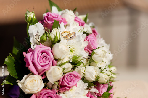 Close-up of the bride s bouquet of pink roses and wedding rings. Wedding.