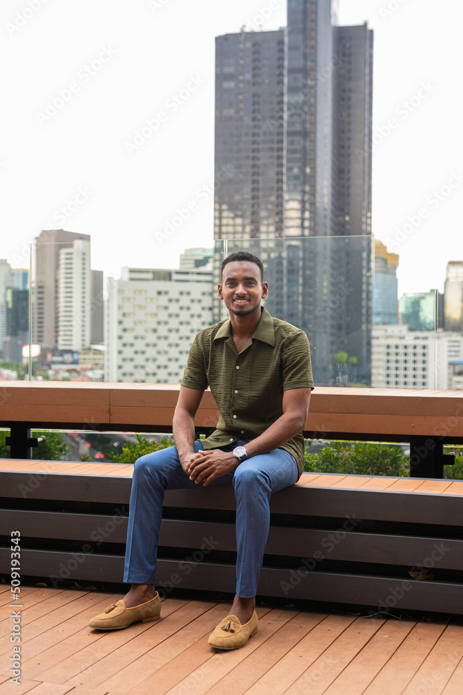 Portrait of handsome young black man outdoors in city