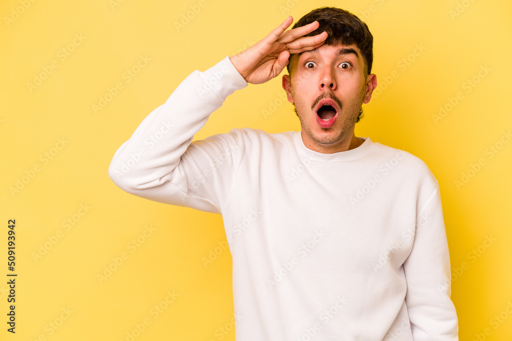 Young caucasian man isolated on yellow background shouts loud, keeps eyes opened and hands tense. Young caucasian man isolated on yellow background shouts loud, keeps eyes opened and hands tense.
