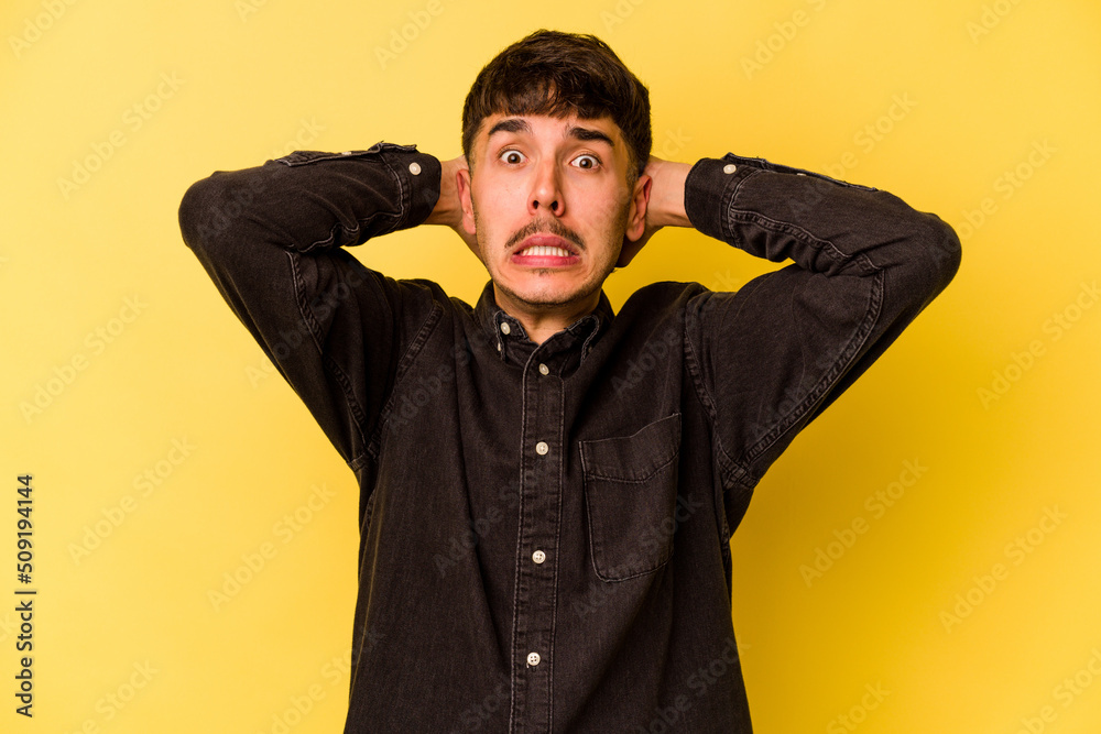 Young caucasian man isolated on yellow background screaming with rage. Young caucasian man isolated on yellow background screaming with rage.