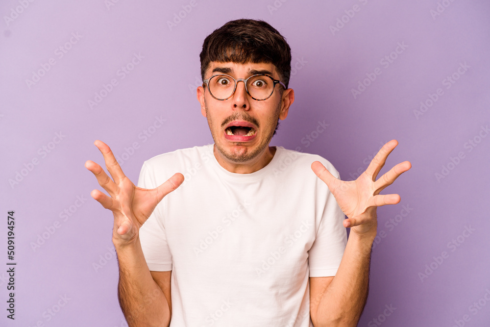 Young caucasian man isolated on purple background screaming to the sky, looking up, frustrated. Young caucasian man isolated on purple background screaming to the sky, looking up, frustrated.