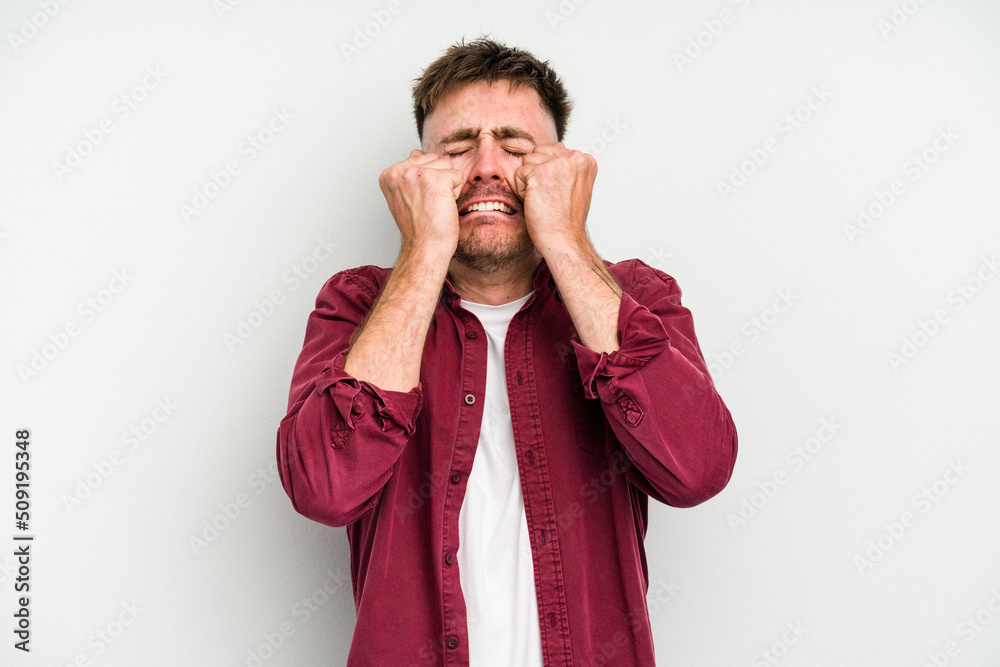 Young caucasian man isolated on white background crying, unhappy with something, agony and confusion concept. Young caucasian man isolated on white background crying, unhappy with something, agony and confusion concept.