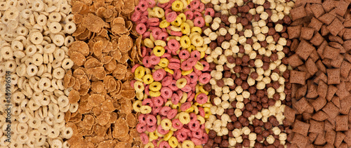 A set of different quick breakfast cereals - rings, balls and pads, top view, long banner