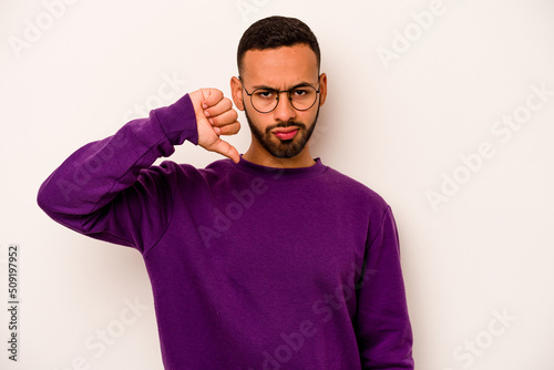 Young hispanic man isolated on white background showing thumb down, disappointment concept. © Asier