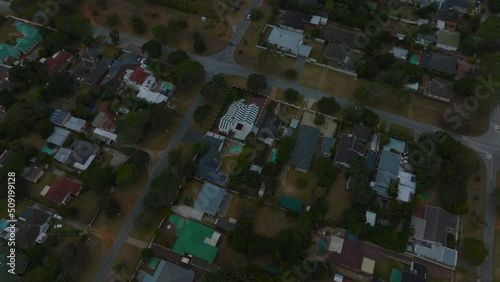 High angle footage of residential houses in urban neighbourhood. Tilt up reveal of city and sea coast. Port Elisabeth, South Africa