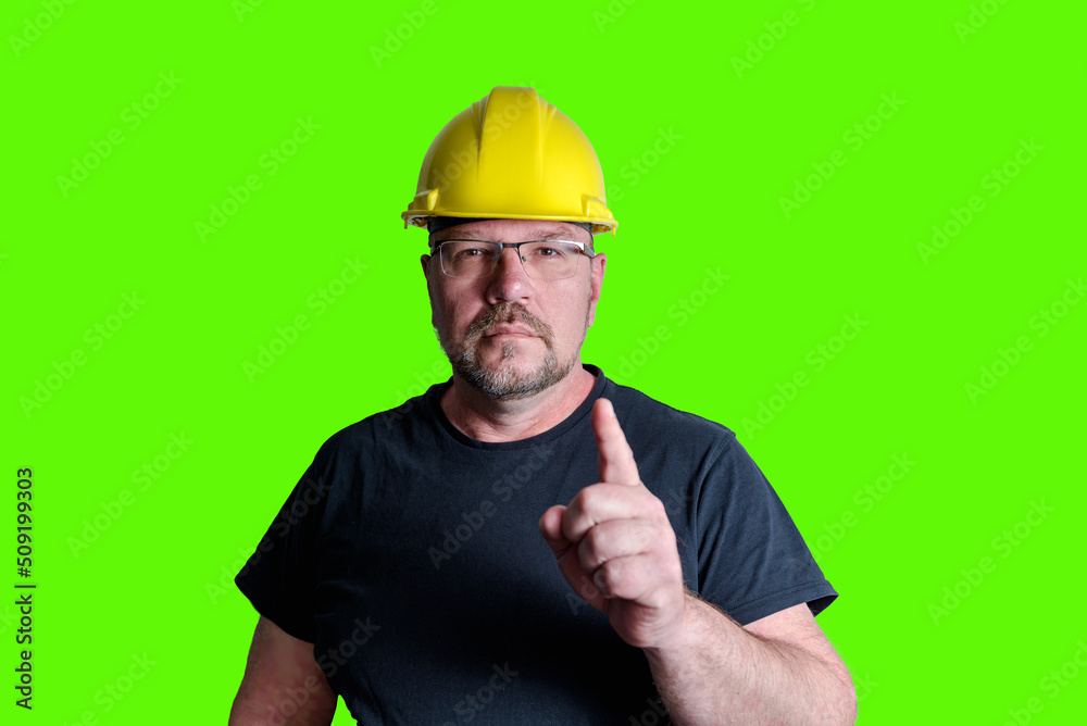 Portrait of a man in a construction helmet. Warning. Forefinger up. Green screen
