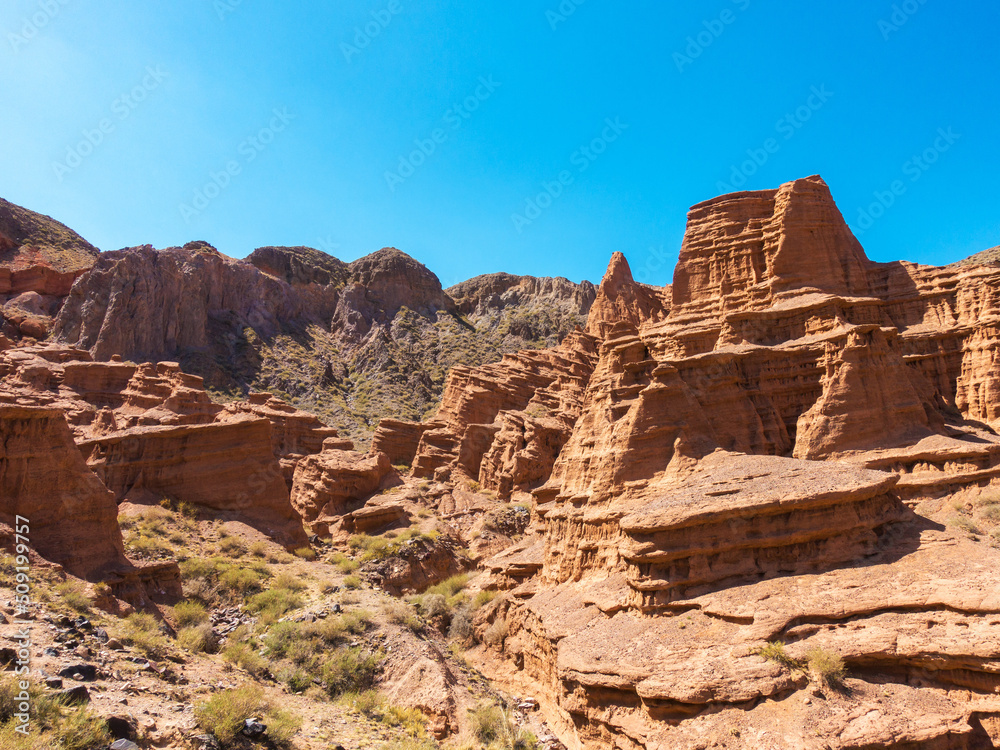 Red tales from clay. Issyk-Kul region in Kyrgyzstan. Beautiful mountain landscape. Tourism and travel.