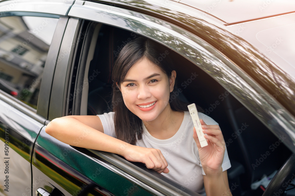 A woman holding atk in car, do a self-collection test for a COVID-19 test, health and safety