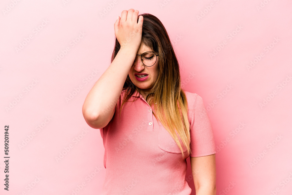 Young caucasian woman isolated on pink background forgetting something, slapping forehead with palm and closing eyes.