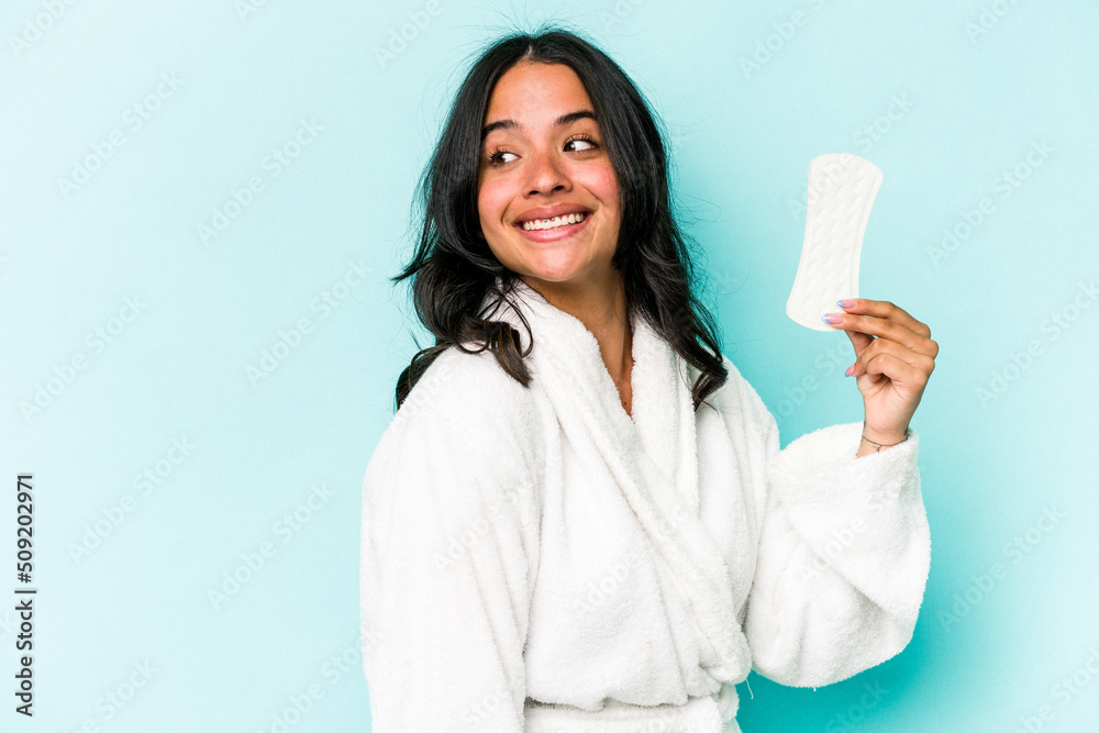 Young caucasian woman holding sanitary napkin isolated on pink background looks aside smiling, cheerful and pleasant. Young caucasian woman holding sanitary napkin isolated on pink background looks aside smiling, cheerful and pleasant.