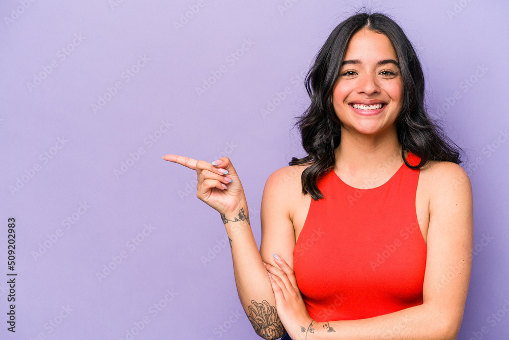 Young hispanic woman isolated on purple background smiling cheerfully pointing with forefinger away. Young hispanic woman isolated on purple background smiling cheerfully pointing with forefinger away.
