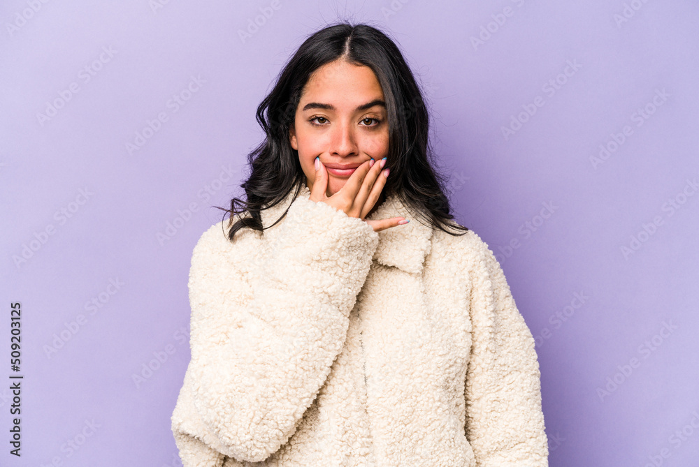 Young hispanic woman isolated on purple background doubting between two options. Young hispanic woman isolated on purple background doubting between two options.