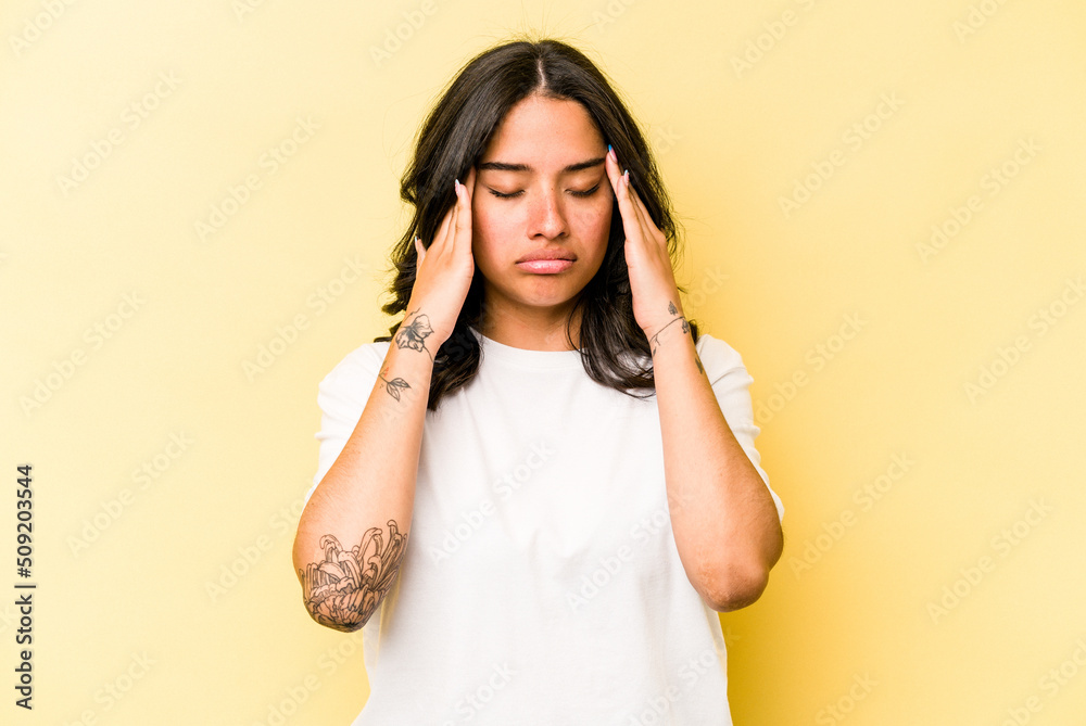Fototapeta premium Young hispanic woman isolated on yellow background having a head ache, touching front of the face.