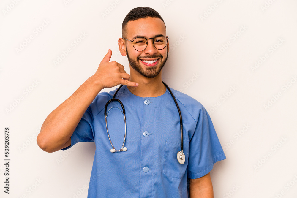 Young hispanic nurse man isolated on white background showing a mobile phone call gesture with fingers.