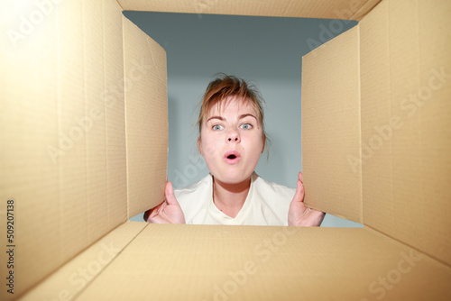 a surprised woman looks into the box. delivery