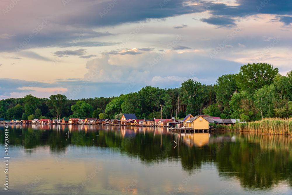 Floating village on Bokod lake in Hungary, dramatic sunset sky