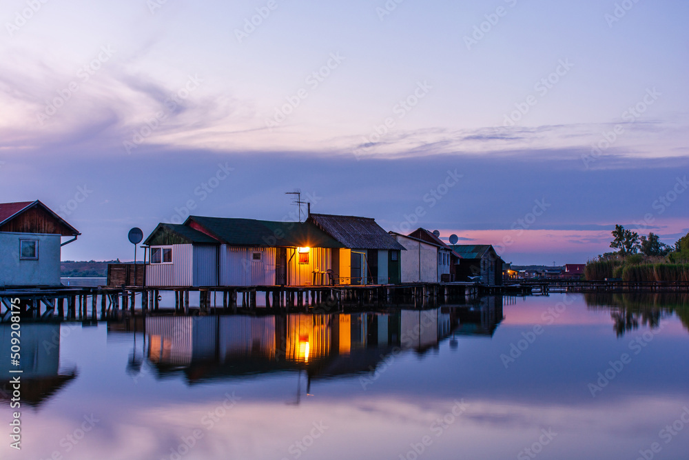 Floating village on Bokod lake in Hungary, dramatic sunset sky Floating village on Bokod lake in Hungary, dramatic sunset sky