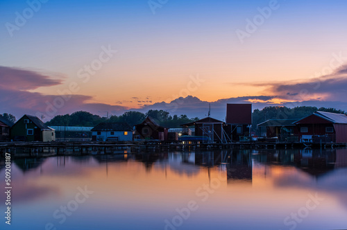 Floating village on Bokod lake in Hungary, dramatic sunset sky © ArturSniezhyn