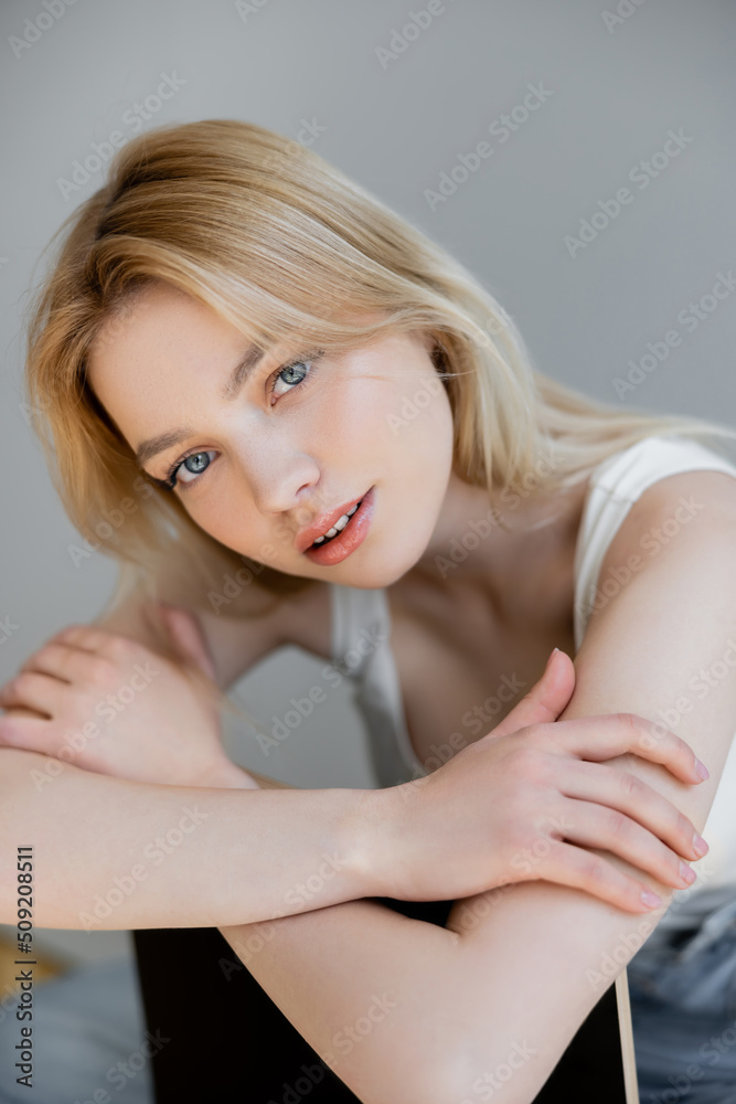 Pretty blonde woman looking at camera at home. Pretty blonde woman looking at camera at home.