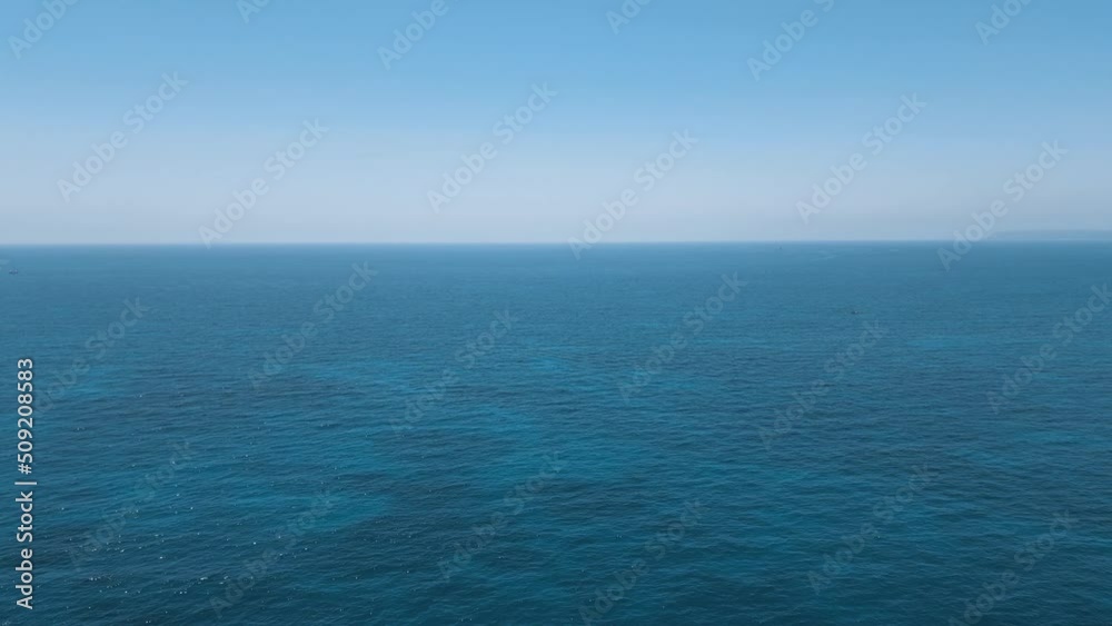 Panoramic aerial view over an expanse of the bright blue sparkling water of the Mediterranean Sea. With a long horizon and only two small boats in the distance. Panoramic aerial view over an expanse of the bright blue sparkling water of the Mediterranean Sea. With a long horizon and only two small boats in the distance.