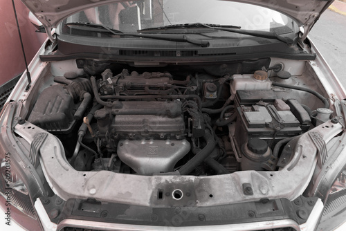 High-angle image of the engine of a white car with the hood open.