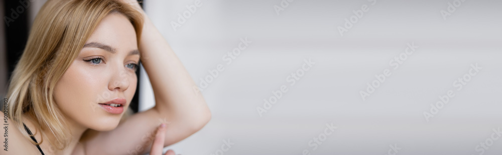 Pretty blonde woman looking away at home, banner.