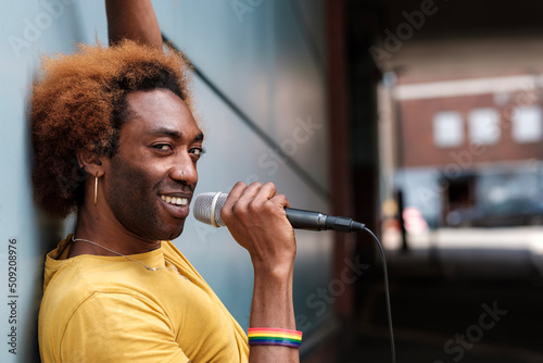 Smiling non-binary young singer performing in a street of London.