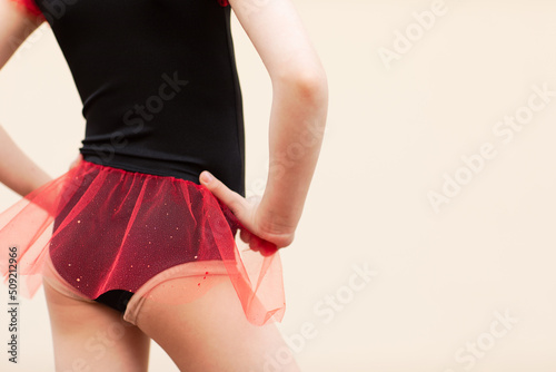 Gymnastics girl posing on beige background with copy space. photo