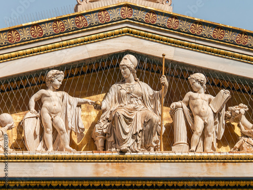 Detail of the gold plated east gable of the building of the University of Athens, Greece. Athena, the goddess of wisdom and knowledge, sits on her throne with demigods and minor deities around her.